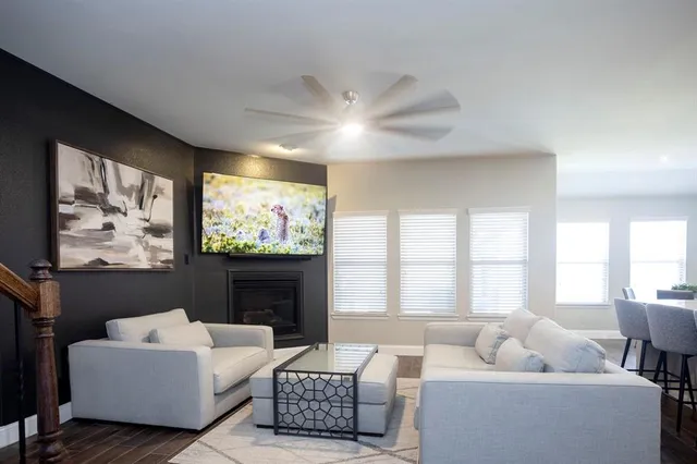 a living room with furniture a large window and a flat screen tv