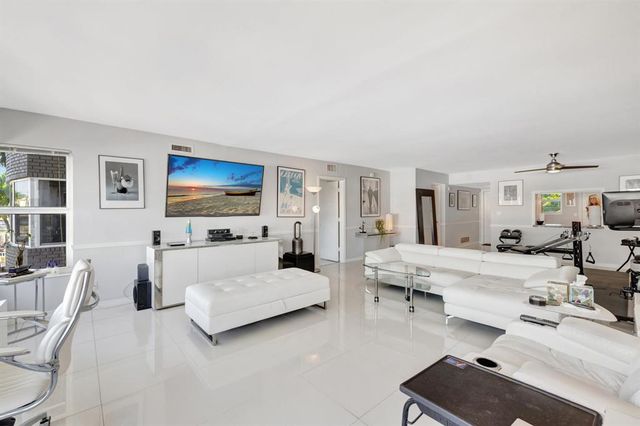 a living room with furniture a flat screen tv and a large window