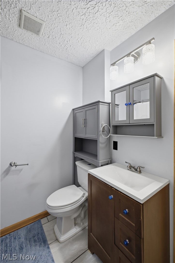 1057 Center Road Clinton, OH 44216 - Photo 15 of 24 Built-in vanity with integrated sink, chrome faucet, and gray over-toilet storage cabinetry