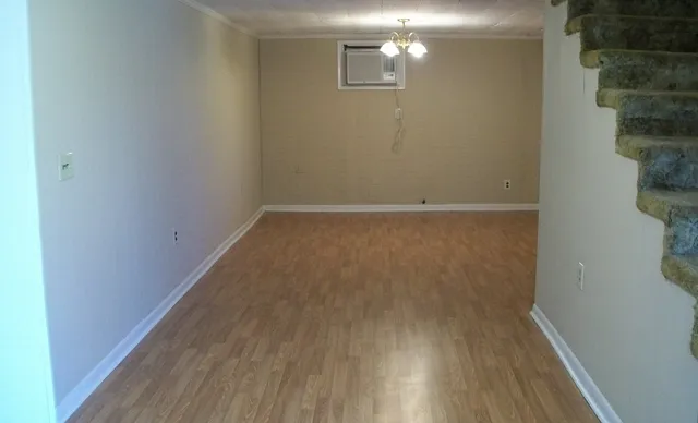 a view of a small space with wooden floor and a window