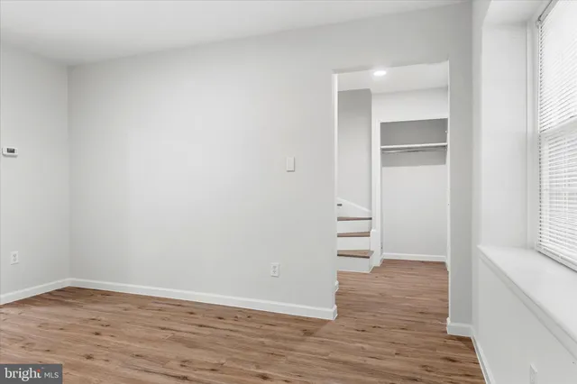 a view of empty room with wooden floor
