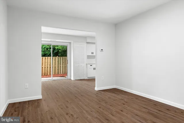 a view of a room with wooden floor and a window