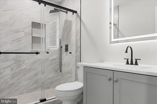 a bathroom with a sink a toilet and shower