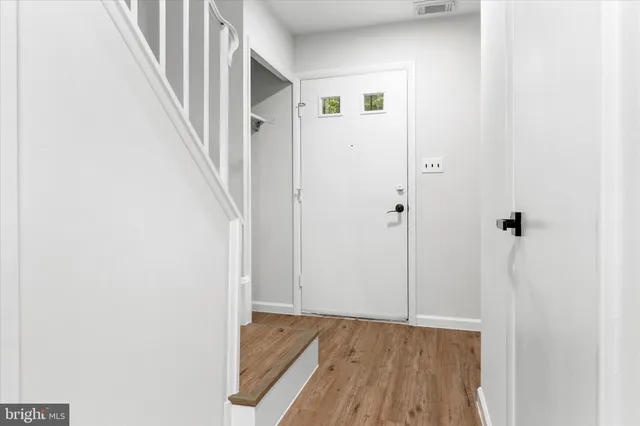 a view of a hallway with wooden floor and entryway