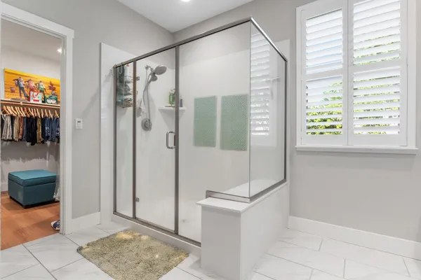 a living room with furniture a flat screen tv and a refrigerator