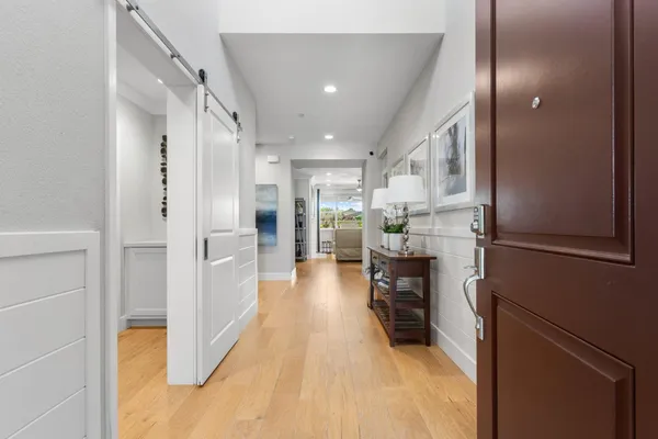 a view of a hallway view with wooden floor and living room