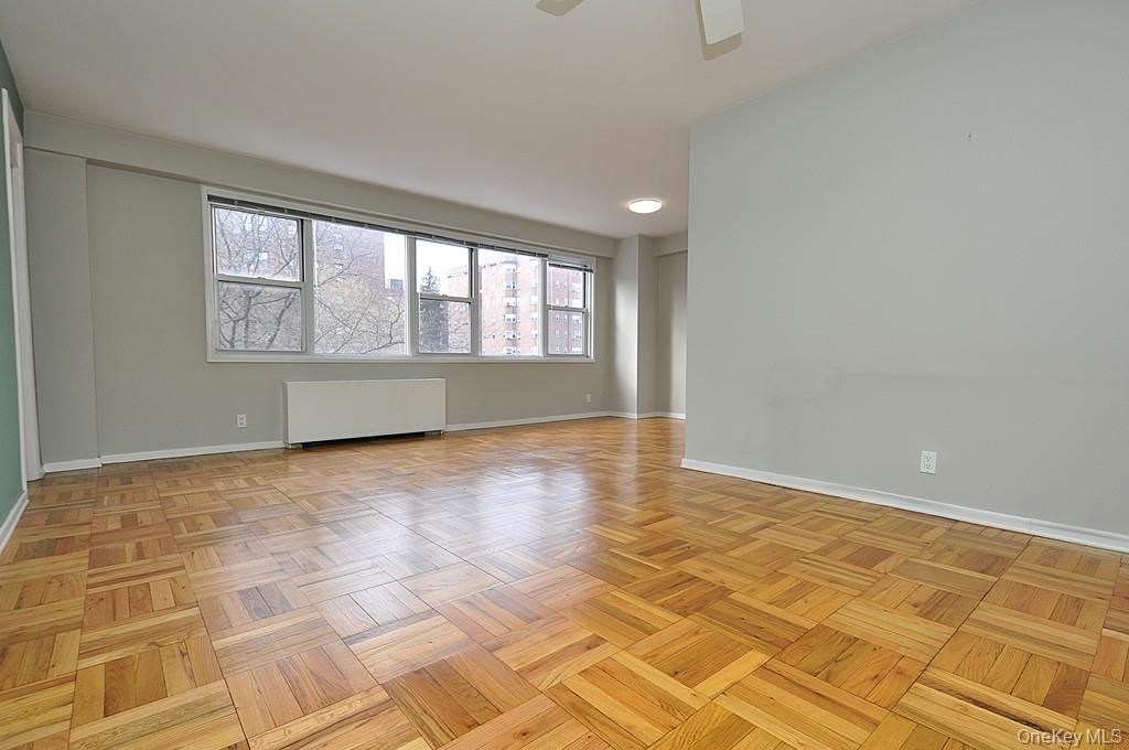 260 Garth Road, Unit 4G5 Scarsdale, NY 10583 - Photo 12 of 48 a view of empty room with wooden floor and fan