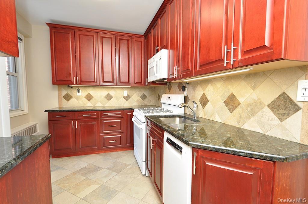 260 Garth Road, Unit 4G5 Scarsdale, NY 10583 - Photo 14 of 48 a kitchen with stainless steel appliances granite countertop a sink stove and cabinets