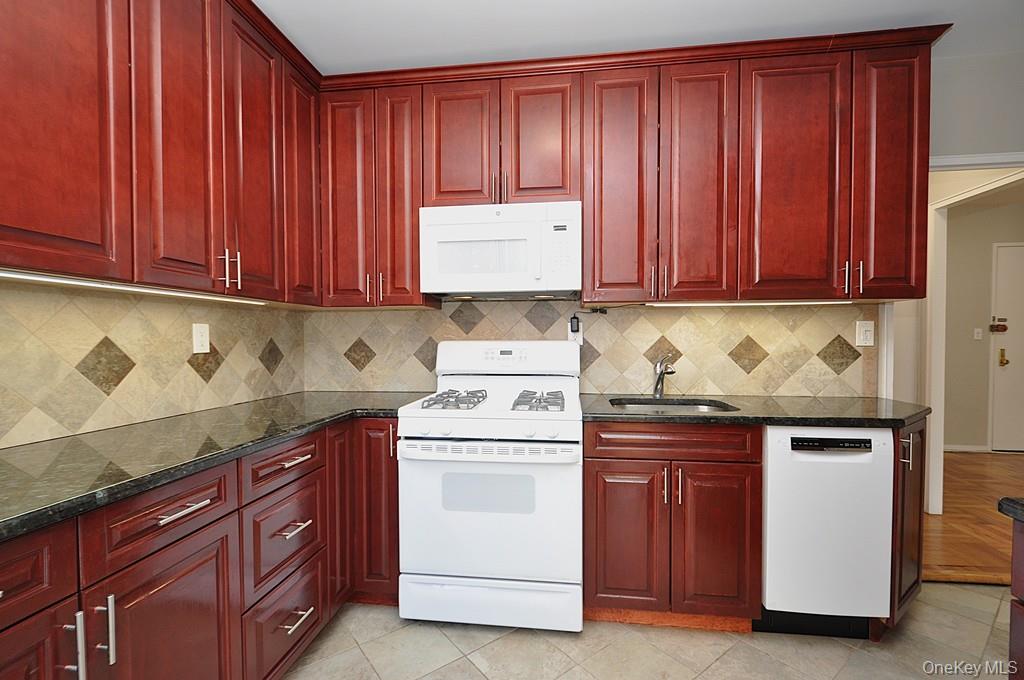 260 Garth Road, Unit 4G5 Scarsdale, NY 10583 - Photo 15 of 48 a kitchen with granite countertop wood cabinets and white appliances