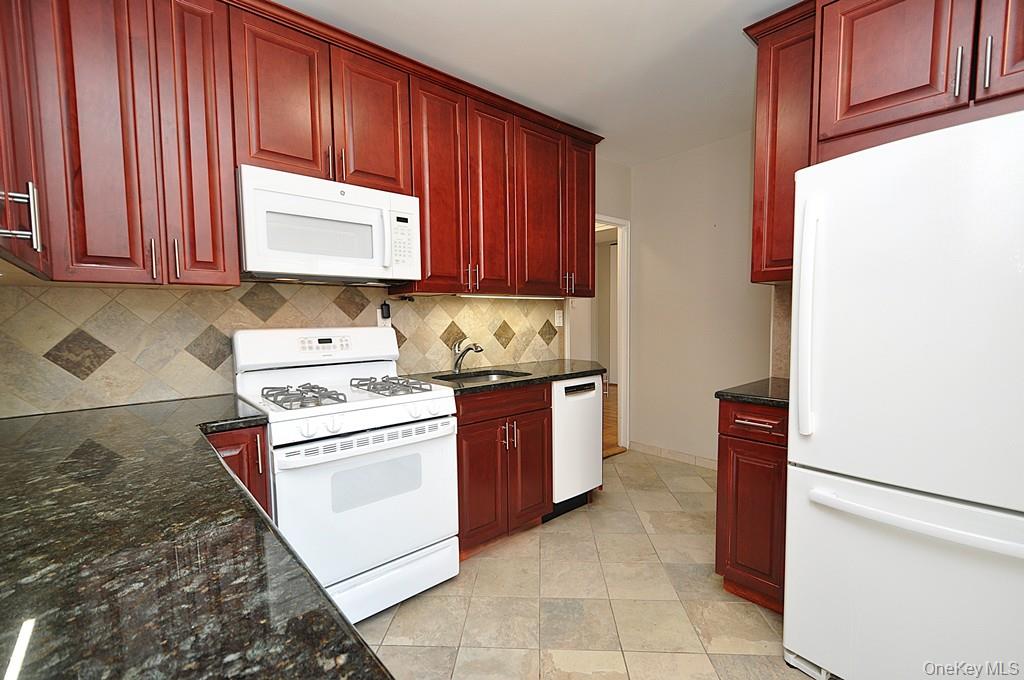 260 Garth Road, Unit 4G5 Scarsdale, NY 10583 - Photo 18 of 48 a kitchen with a stove top oven sink and cabinets