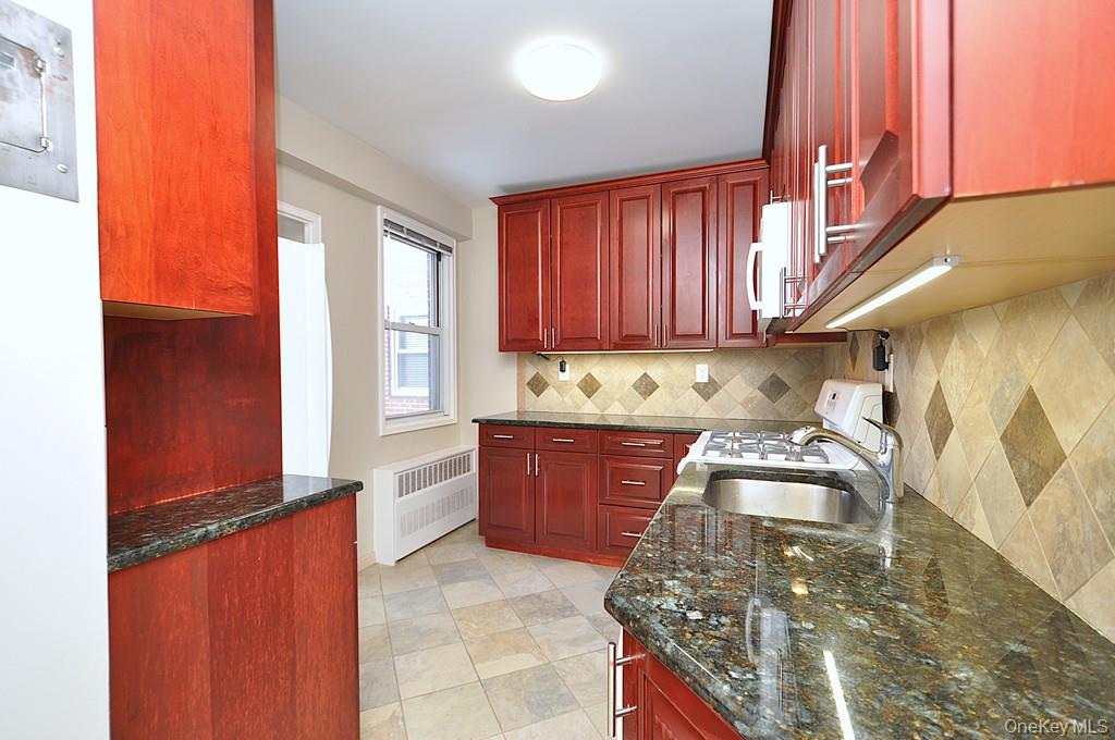 260 Garth Road, Unit 4G5 Scarsdale, NY 10583 - Photo 19 of 48 a kitchen with stainless steel appliances granite countertop a stove a sink and a microwave