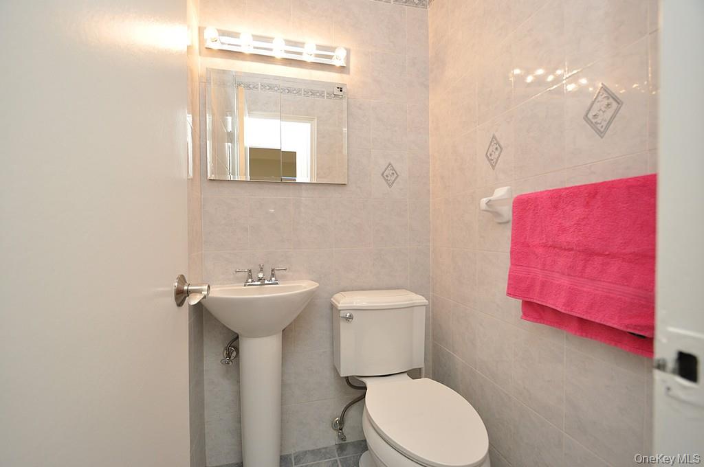 260 Garth Road, Unit 4G5 Scarsdale, NY 10583 - Photo 24 of 48 a bathroom with a toilet sink and mirror
