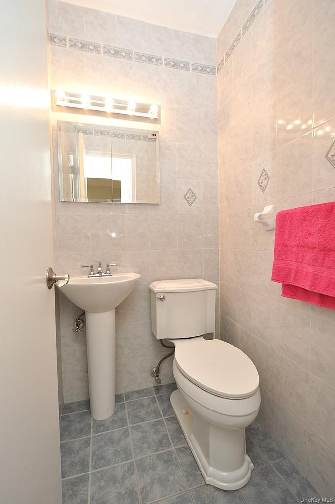 260 Garth Road, Unit 4G5 Scarsdale, NY 10583 - Photo 25 of 48 a bathroom with a toilet sink and mirror