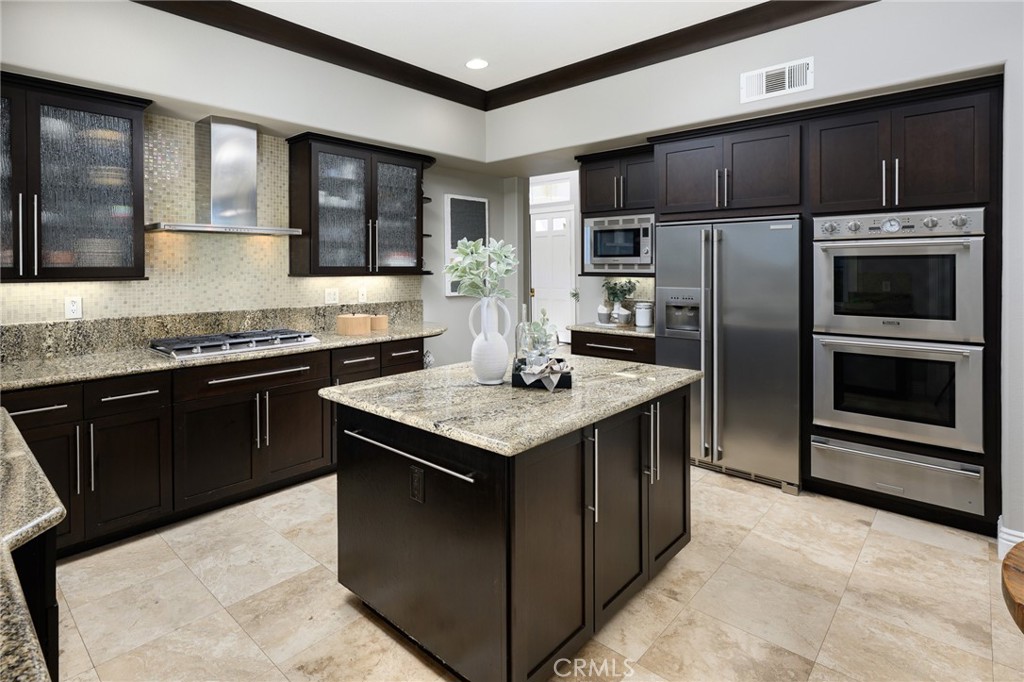 12 Serna Rancho Santa Margarita, CA 92688 - Photo 5 of 75 The gourmet kitchen features granite countertops, espresso-colored cabinets with glass insets, under cabinet lighting, Thermador double ovens.