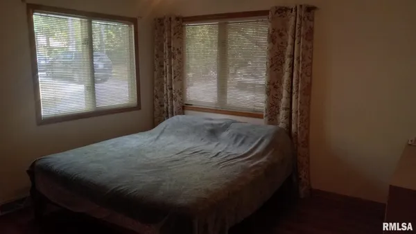 a bed sitting in a bedroom next to a window