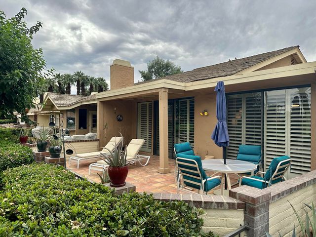 a view of a patio with chair and tables back yard of the house
