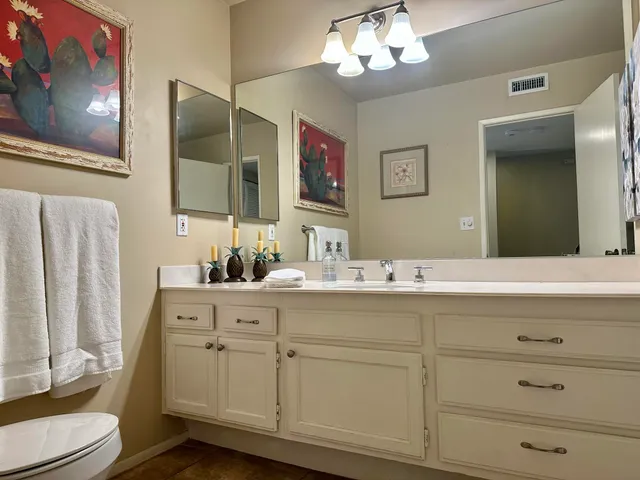 a bathroom with a sink mirror and toilet