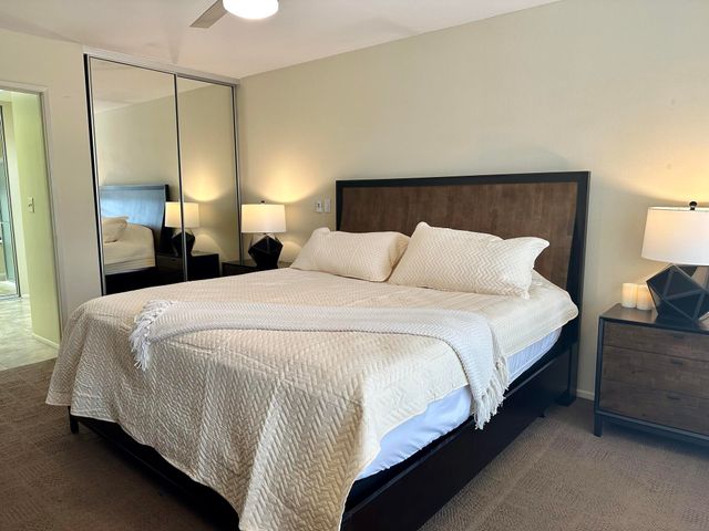 a bedroom with a bed a lamp and a large closet