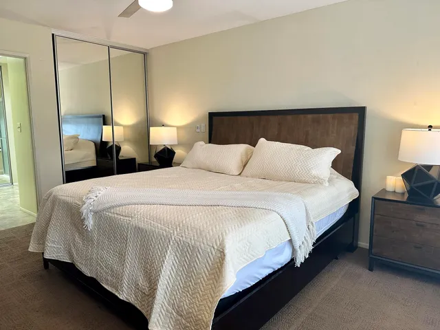 a bedroom with a bed a lamp and a large closet