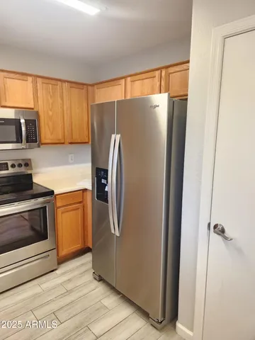 a kitchen with stainless steel appliances granite countertop a refrigerator and a stove top oven