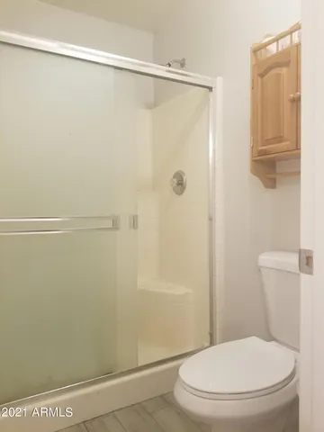 a white toilet sitting next to a shower
