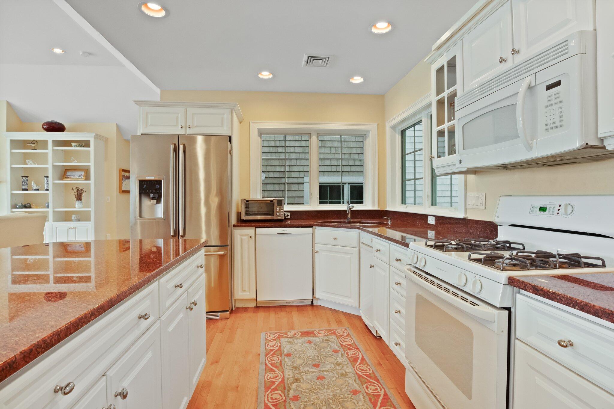 99 Center Lane Centerville, MA 02632 - Photo 24 of 89 a kitchen that has a lot of cabinets in it and wooden floors