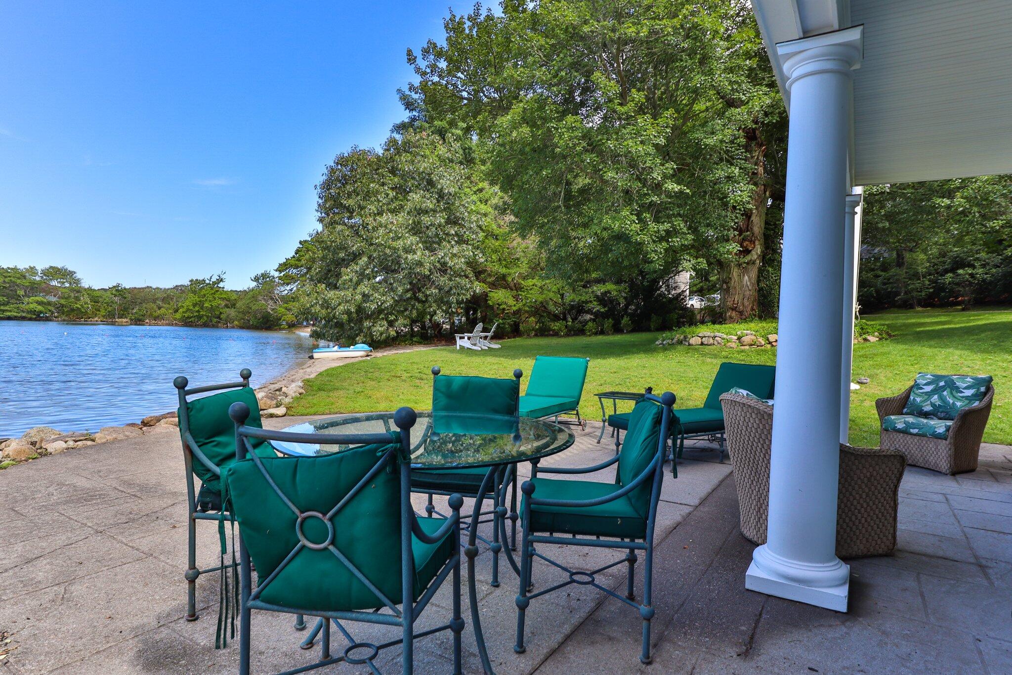 99 Center Lane Centerville, MA 02632 - Photo 63 of 89 a view of a chairs and table in the patio and a lake view