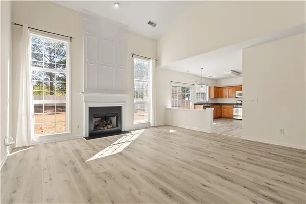 a view of empty room with wooden floor and fireplace