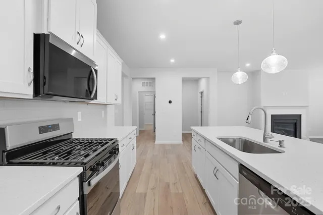 a kitchen with a sink and steel appliances