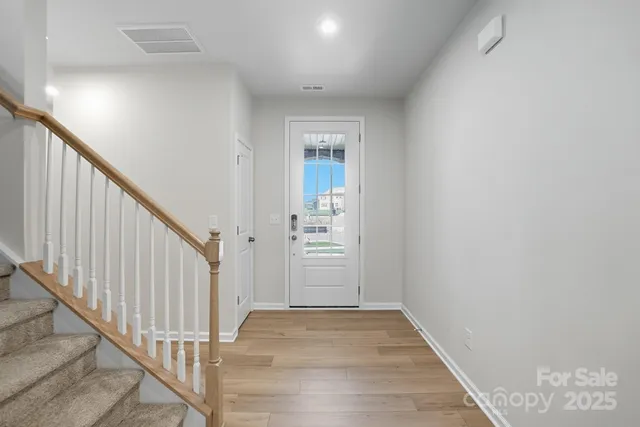 a view of a hallway with wooden floor and entryway
