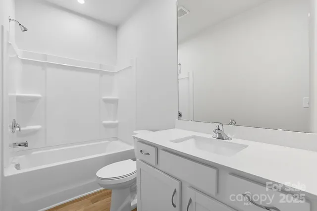 a bathroom with a sink toilet vanity and bathtub