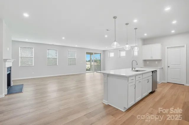 a large kitchen with granite countertop a large counter top a sink stainless steel appliances and cabinets