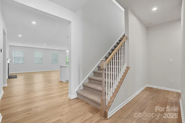 a view of a hallway with wooden floor and staircase