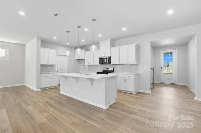 a kitchen with white cabinets stainless steel appliances