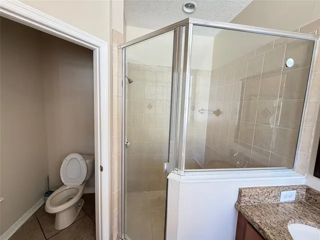 a bathroom with a granite countertop sink toilet and shower