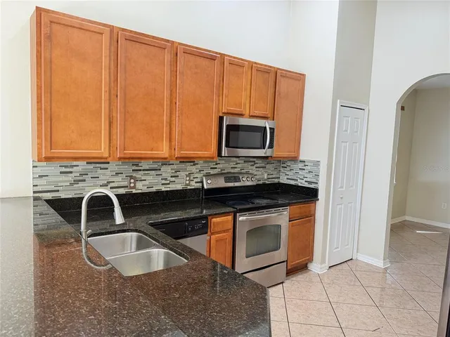 a kitchen with granite countertop a sink and a microwave