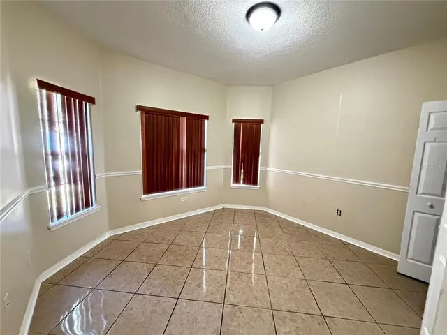 a view of an empty room with window and hardwood floor