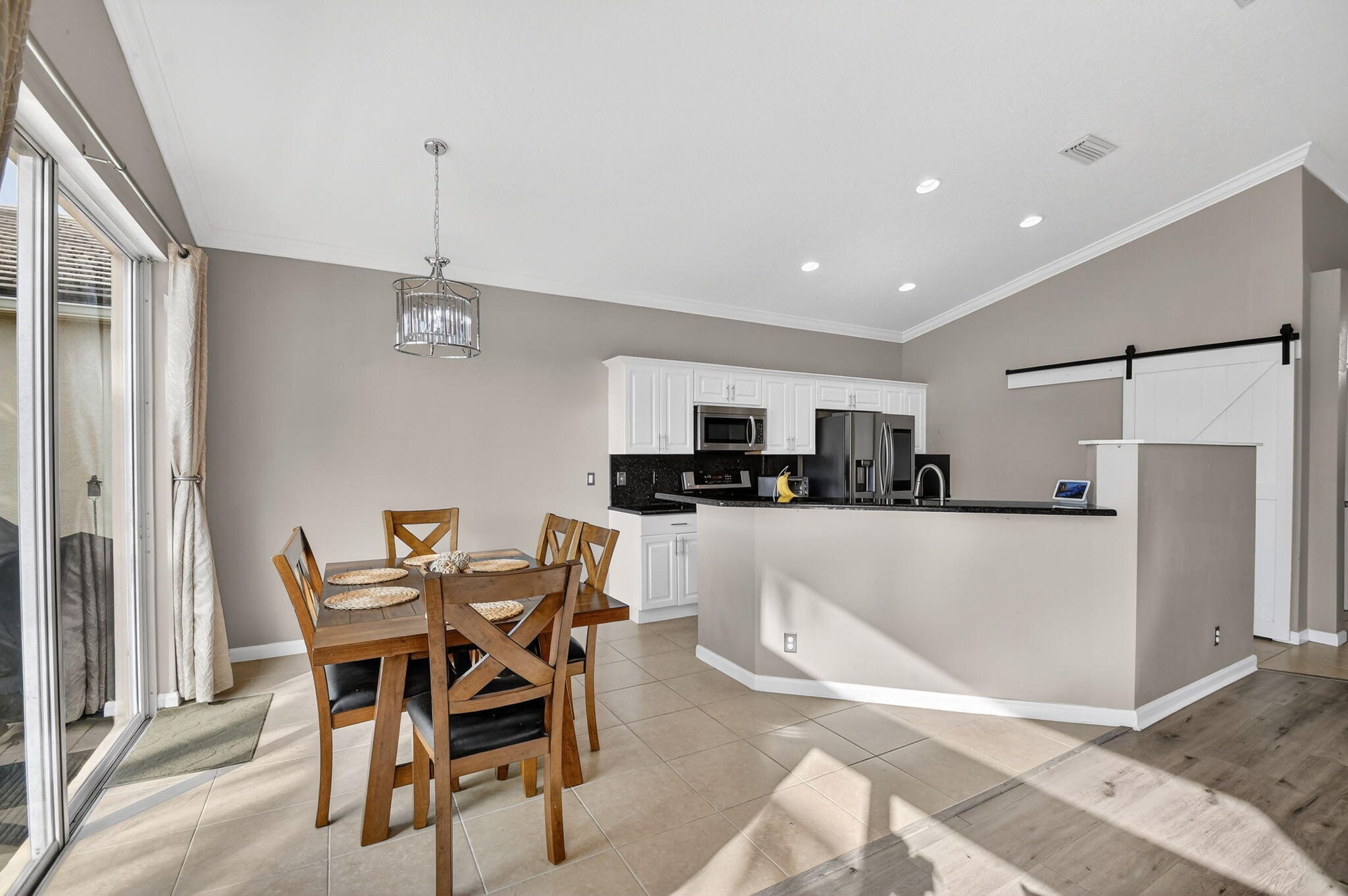 10202 Clubhouse Turn Road Lake Worth, FL 33449 - Photo 7 of 21 a kitchen with stainless steel appliances a table and chairs in it