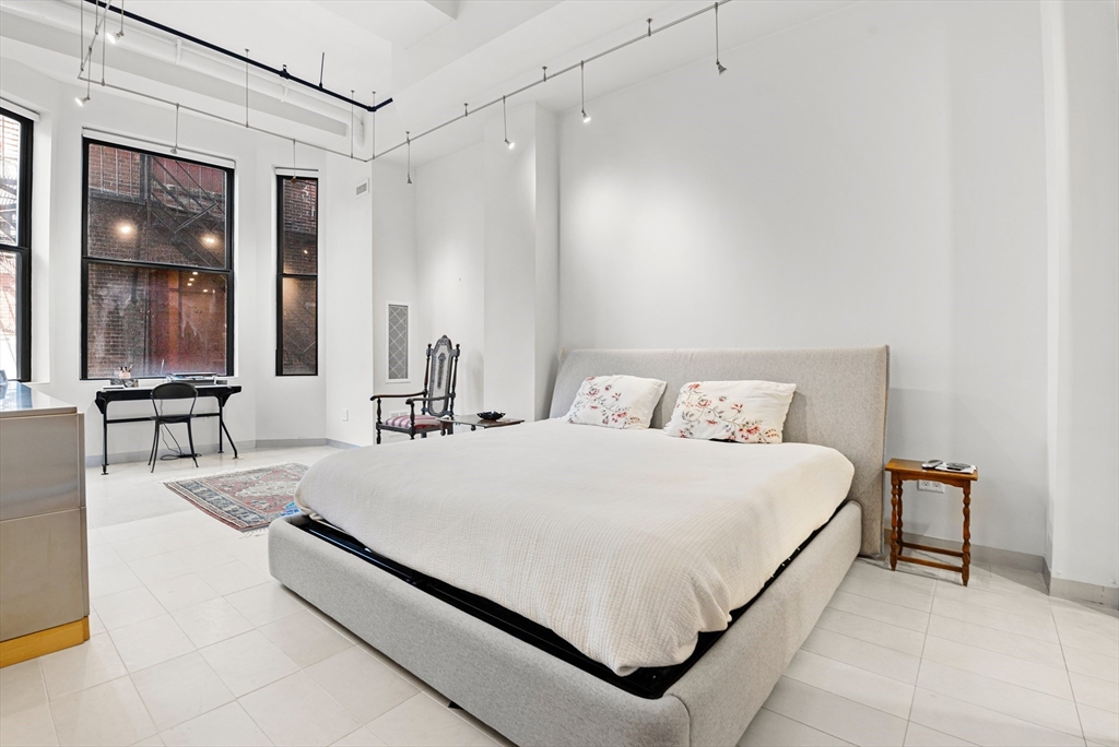 453 Washington Street, Unit 3A Boston, MA 02111 - Photo 11 of 18 a bed room with a bed and a large mirror