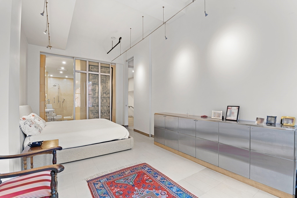 453 Washington Street, Unit 3A Boston, MA 02111 - Photo 12 of 18 a bedroom with a bed and a large mirror