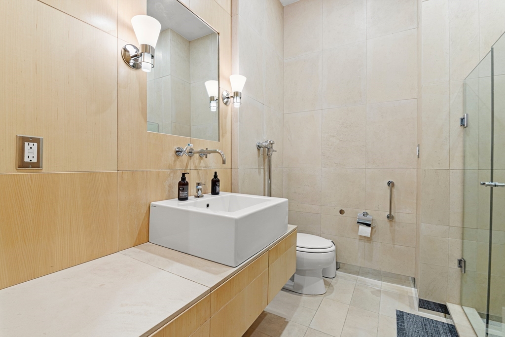 453 Washington Street, Unit 3A Boston, MA 02111 - Photo 17 of 18 a bathroom with a sink a toilet and shower