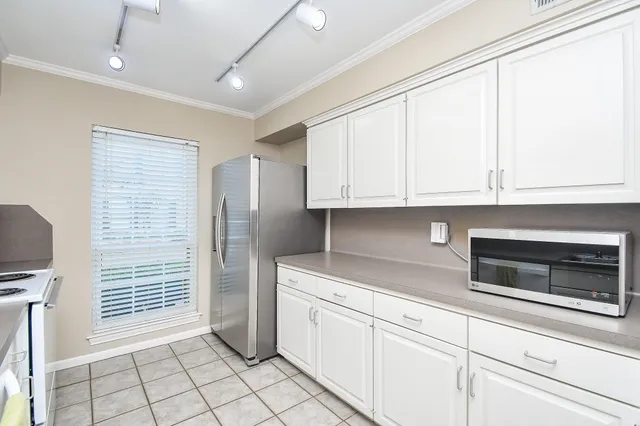 a kitchen with granite countertop white cabinets stainless steel appliances and sink