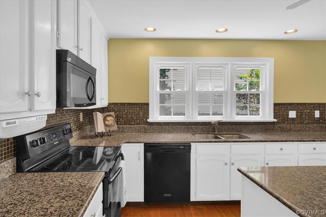 12516 Eagle Ridge Road Henrico, VA 23233 - Photo 15 of 48 Kitchen with wood-type flooring, natural light, electric range oven, dishwasher, microwave, dark granite-like countertops, and white cabinets