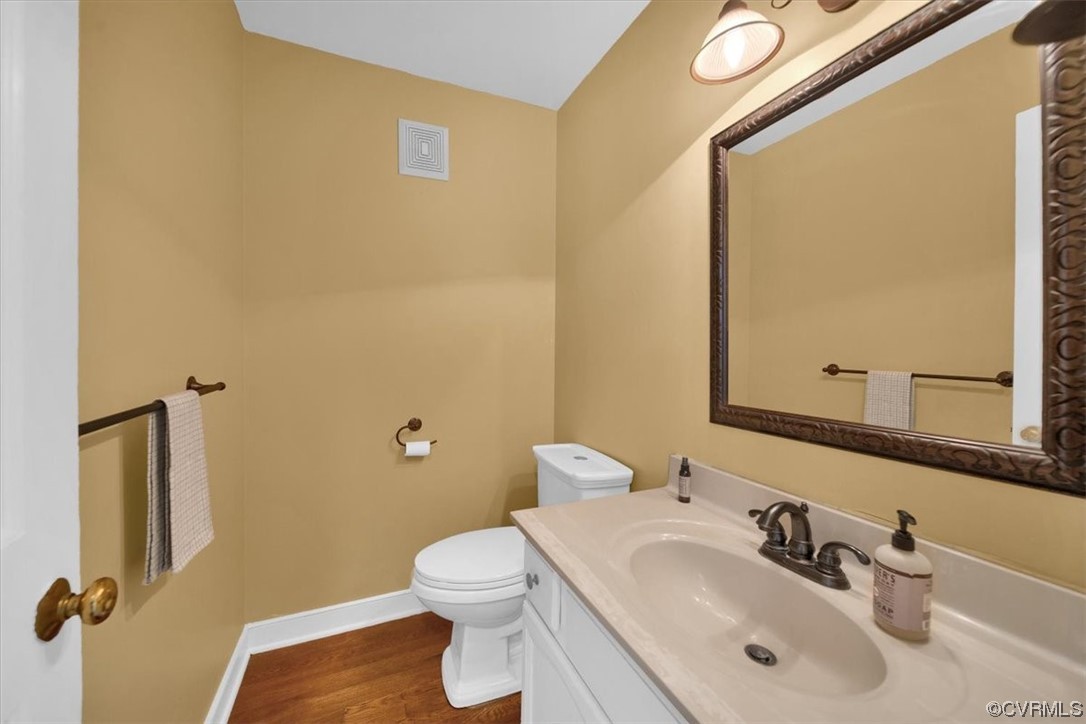 12516 Eagle Ridge Road Henrico, VA 23233 - Photo 20 of 48 Half bathroom with hardwood floors, large vanity, mirror, and toilet