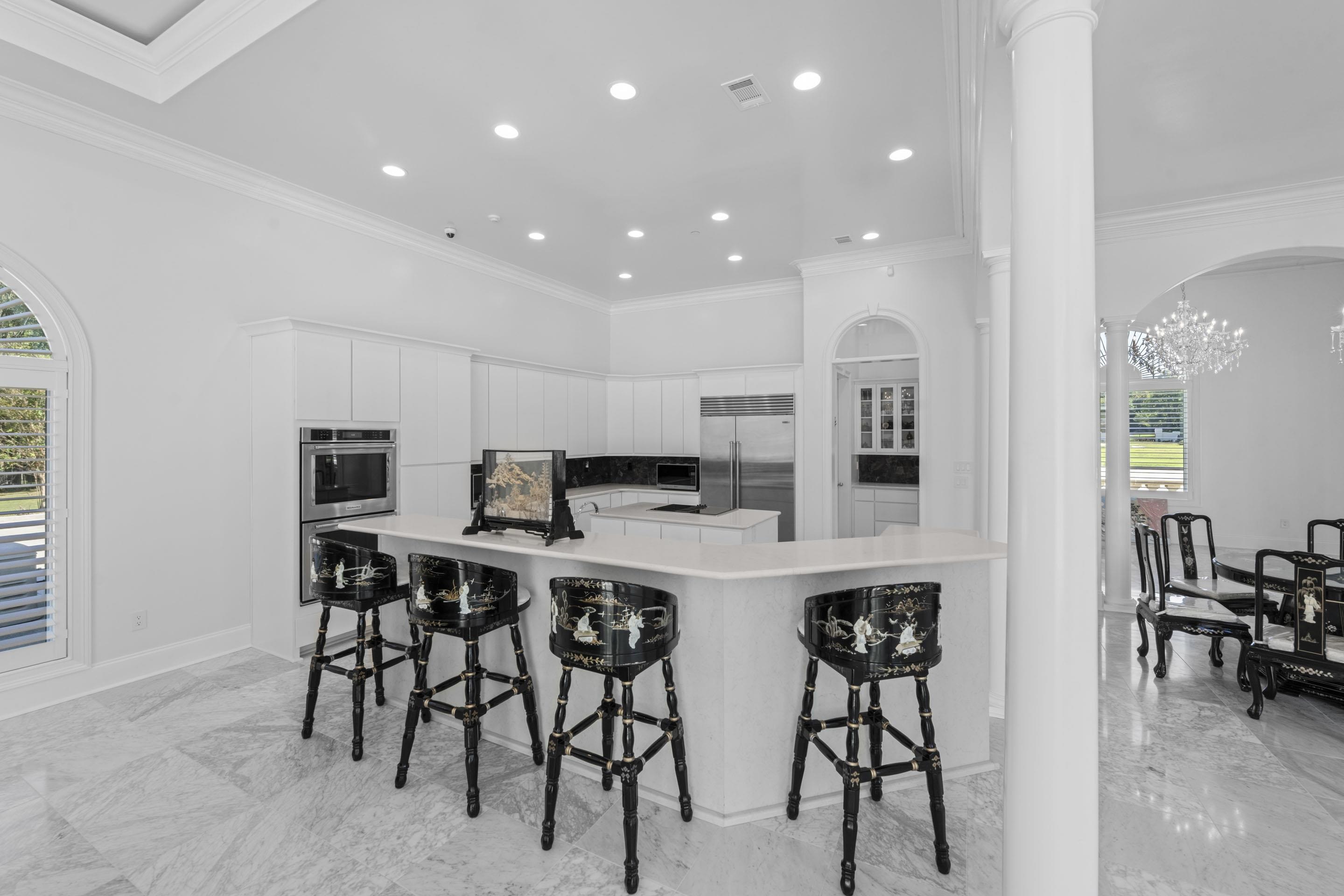 881 Bray Station Road Collierville, TN 38017 - Photo 8 of 40 Kitchen featuring healthy amount of natural light, crown molding, arched walkways, a breakfast bar, and light marble finish floors
