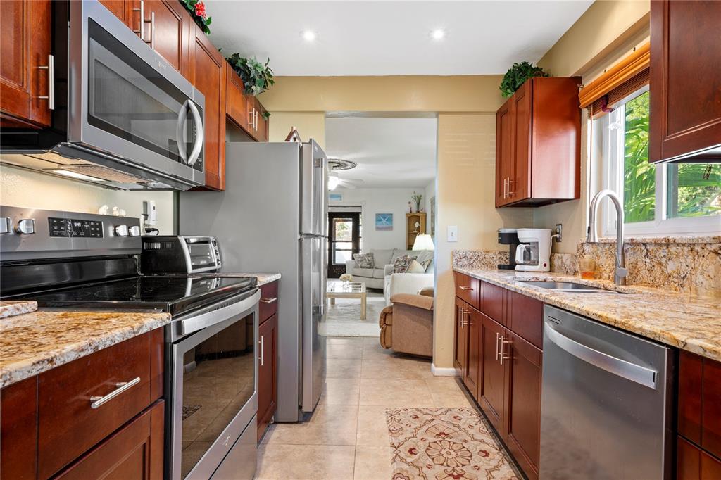 7360 Ulmerton Road, Unit 15D Largo, FL 33771 - Photo 12 of 75 a kitchen with stainless steel appliances granite countertop a stove a sink and a microwave