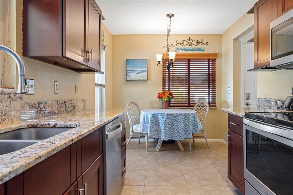 7360 Ulmerton Road, Unit 15D Largo, FL 33771 - Photo 14 of 75 a kitchen with stainless steel appliances granite countertop a sink stove and cabinets