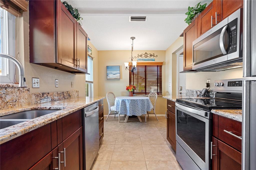 7360 Ulmerton Road, Unit 15D Largo, FL 33771 - Photo 15 of 75 a kitchen with stainless steel appliances granite countertop a sink stove and refrigerator