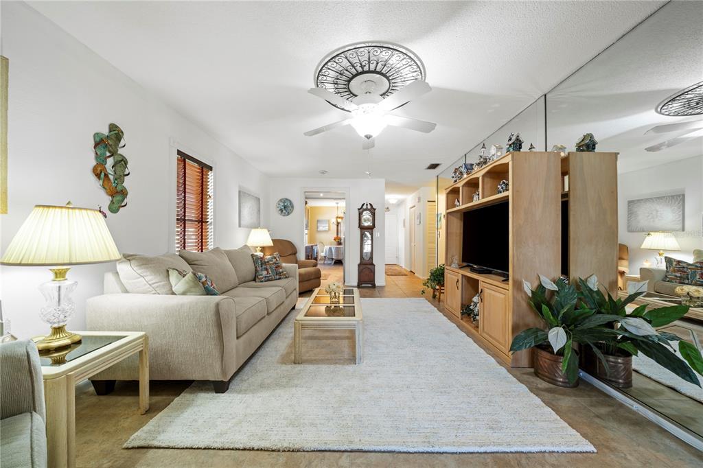 7360 Ulmerton Road, Unit 15D Largo, FL 33771 - Photo 19 of 75 a living room with furniture a flat screen tv and a potted plant