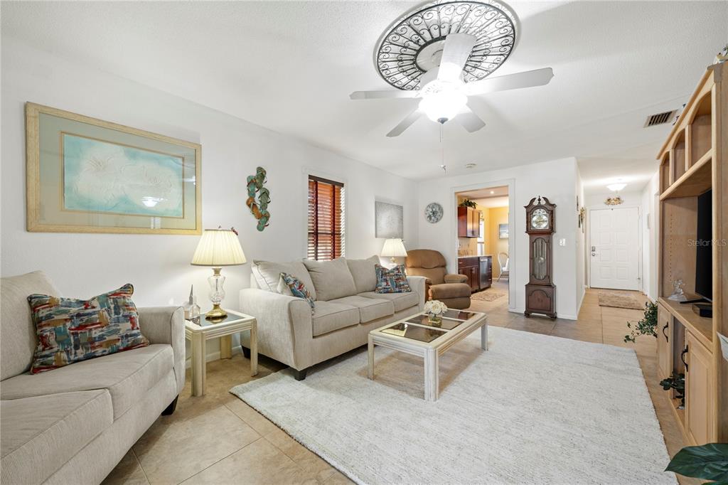 7360 Ulmerton Road, Unit 15D Largo, FL 33771 - Photo 21 of 75 a living room with furniture a chandelier and a flat screen tv